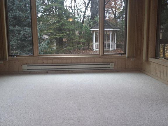 Sunroom has knotty pine walls and overlooks the private back yard