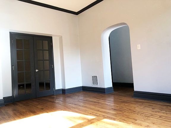 Exposed brick, an arched doorway, and French doors give the living room plenty of character.