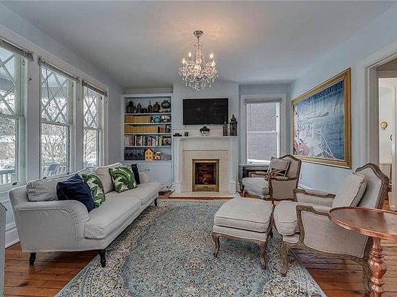 Inviting Living Room with Original Pine Flooring, a Gorgeous Decorative Fireplace Mantle and Built-In Bookcase
