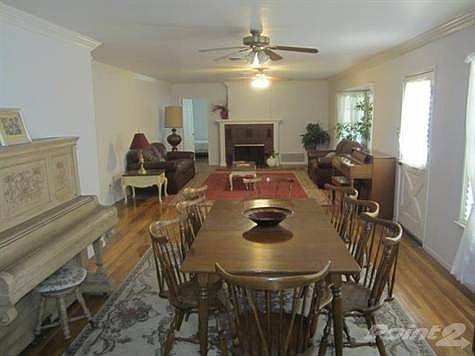 Dining & Living room exhibiting the beautiful wood floors and fireplace. The windows offer a beautiful view of the front yard