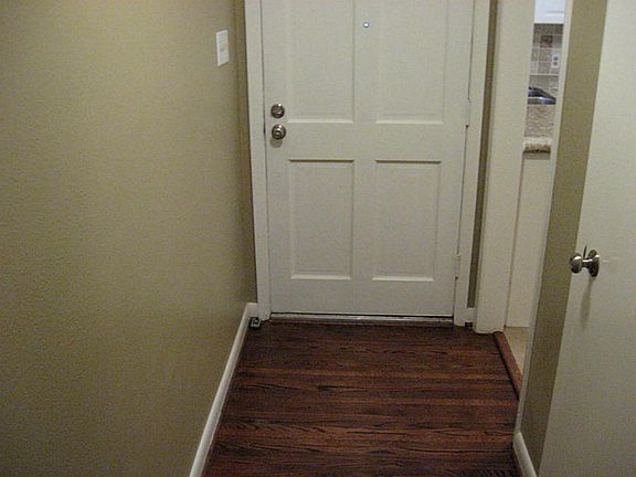 The entryway has wood flooring and solid wood door, for priv