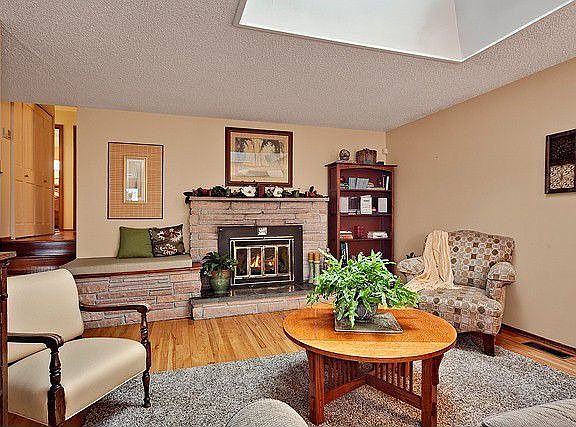 This wonderful living room offers a wood fire place, skylight and hardwood floors.