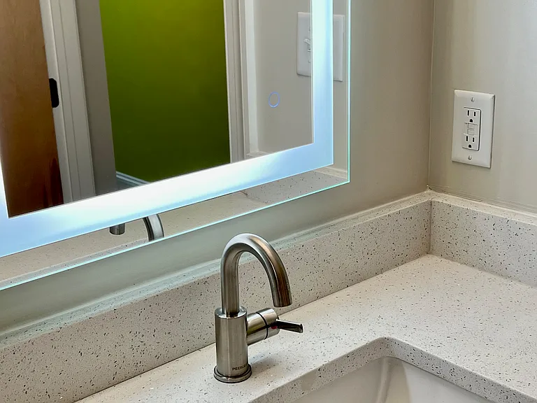 Vanity & mirror detail showing sparkly quartz countertop.