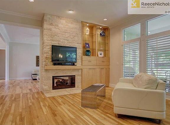 Hearth room opens from kitchen includes built in's, stone fireplace & plantation shutters.