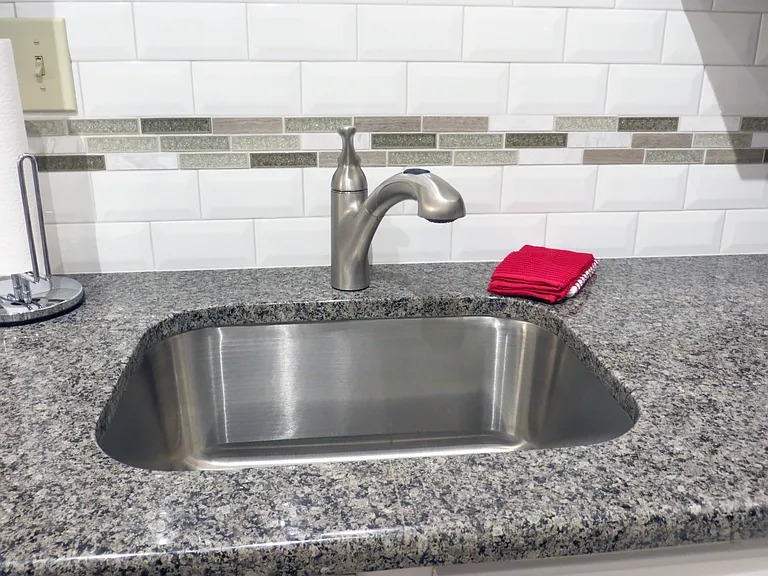 Upgraded kitchen with granite counter tops, beveled subway tile and mosaic tile back splash.