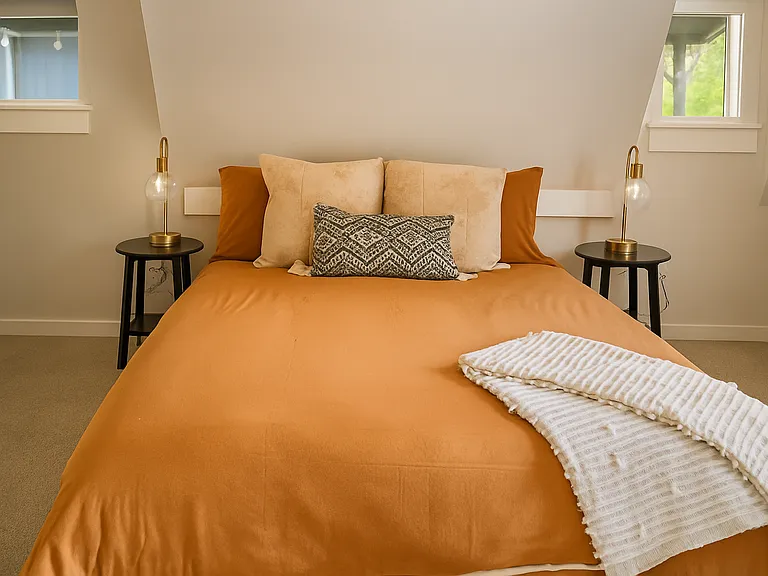 Relax in this cozy bedroom, featuring a plush queen bed and warm, earthy tones_perfect for a restful night's sleep