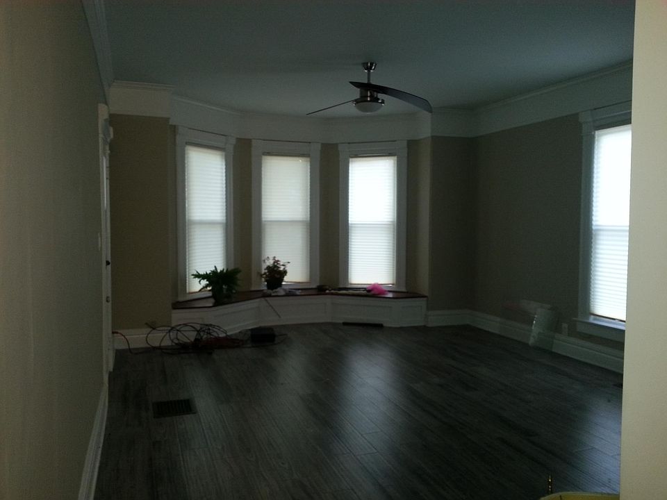 Large living room with solid surface flooring in neutral tones of grey and putty wall color