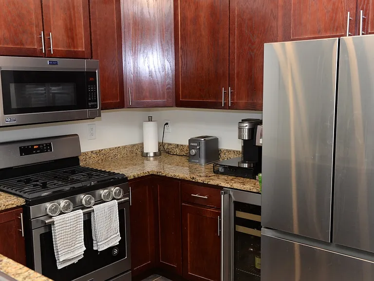 Kitchen with brand new wine fridge and adjacent brand new washer/dryer.
