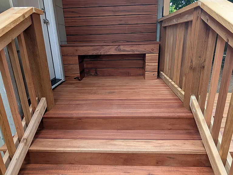 Brand-new Brazilian Tigerwood hardwood entry deck with inlaid bench and backrest.