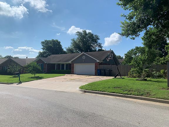 Double wide driveway with double wide wooden gate to paved parking in back yard.
