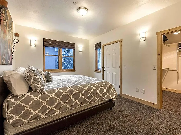 Primary bedroom with King Bed and ample closet space including 2 dressers, plus access to a private patio with outdoor furniture and self-contained fire pit