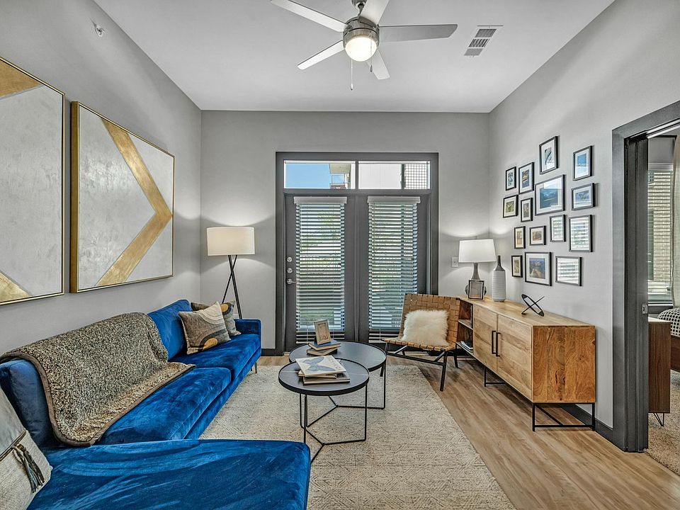 Living room with wood-inspired flooring leading out to the balcony