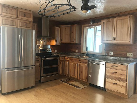 Kitchen with ceiling fan and hanging pot rack.