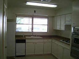 Kitchen with lots of cabinets and tiled floors.