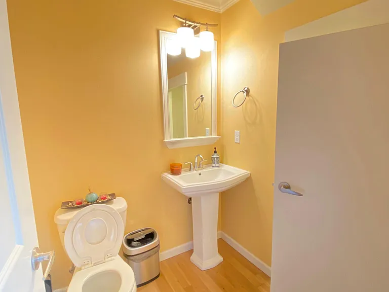Powder room with access to below-the-stair-storage with ample space.