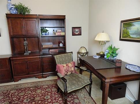 The study features plantation shutters and French Doors