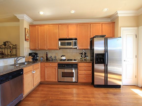Sunny kitchen offers maple cabinetry, granite countertops, and SS appliances.