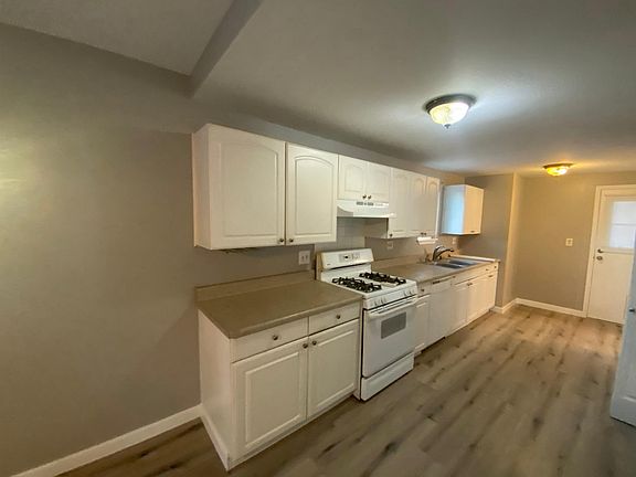Galley style kitchen including full range unit, double sinks and dishwasher.