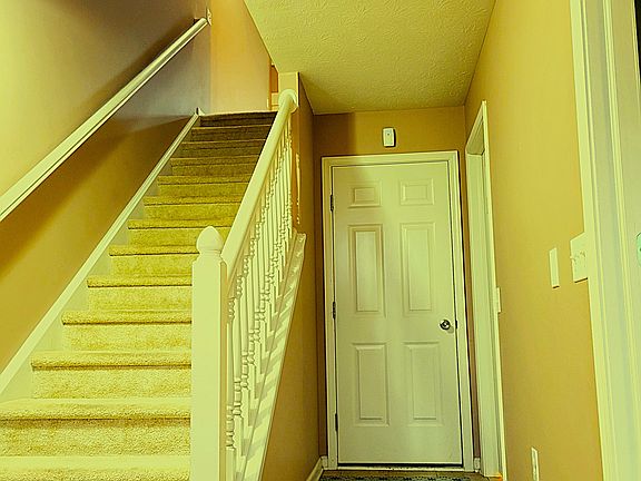 Enter your home directly from the garage into this clean and welcoming tiled entryway, complete with easy access to the upper floors and a bright, open design that makes everyday living convenient and comfortable.