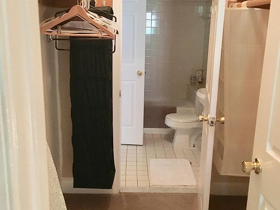 Large walk-in closet connects to the bedroom on one side and the bathroom on the other.