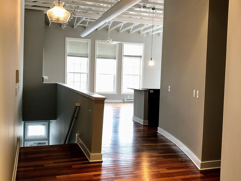 View of the front door, staircase, and direction towards the kitchen/living space