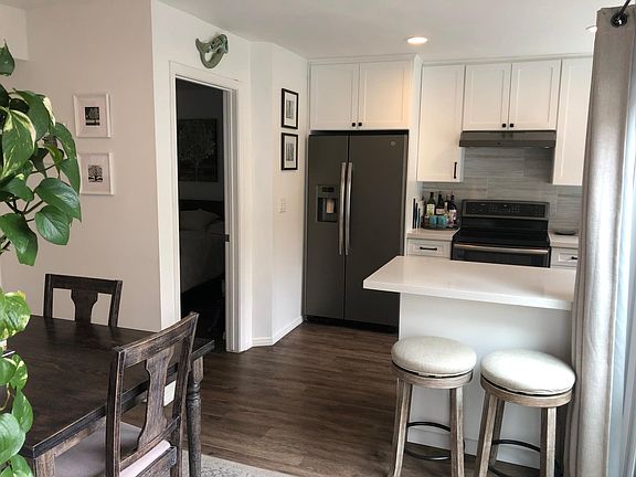 Built in side by side refrigerator with water and ice dispenser. Counter with bar stools.