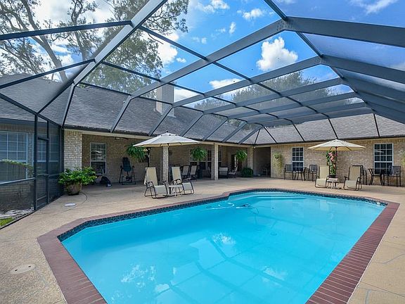 This smaller 1-story home with a large screened-in pool is "A GEM"!