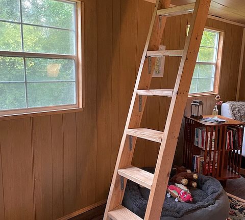 Wooden ladder to lofted bed upstairs.