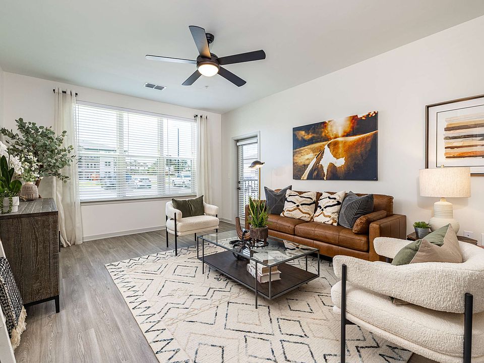 Large window and ceiling fan in apartment living rooms at The Groves at Lake Juliana