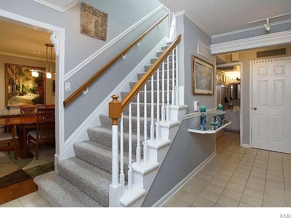 Foyer with wide stairs, tile floor & molding