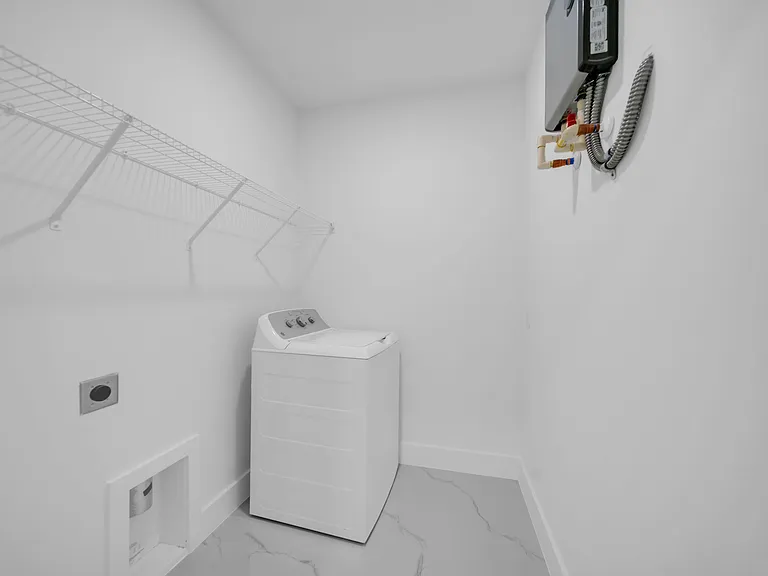 Dedicated laundry closet with wire shelving for supplies and convenient in-home washer hookups for everyday use.