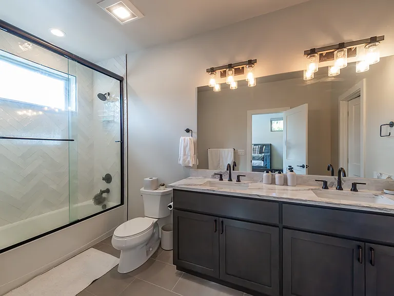 Full ensuite bathroom off the upper-level primary suite, offering privacy and comfort with sleek finishes and modern design!