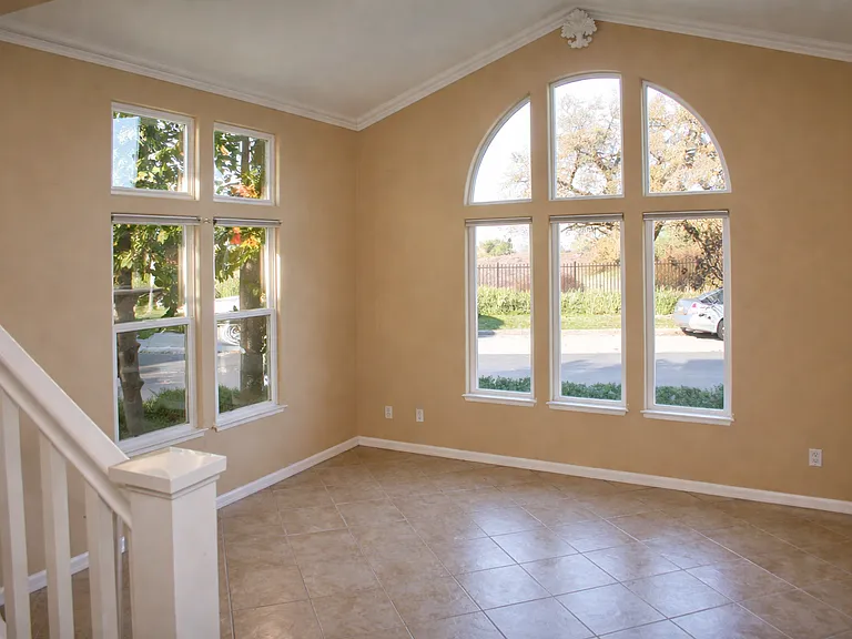 Open living space with high ceilings and oversized windows offering excellent natural light and views