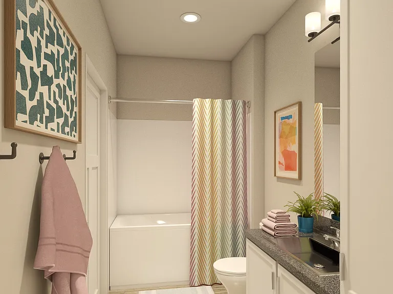 Greenwood Commons apartment bathroom showing a sink, mirror, bathtub, and overhead lighting.