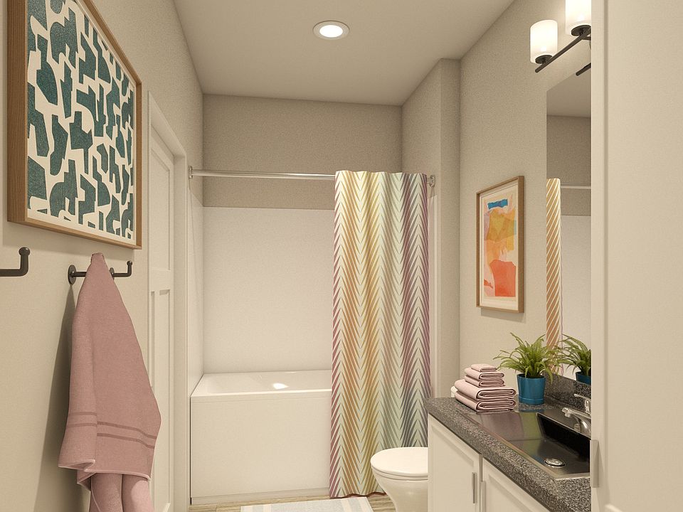 Greenwood Commons apartment bathroom showing a sink, mirror, bathtub, and overhead lighting.