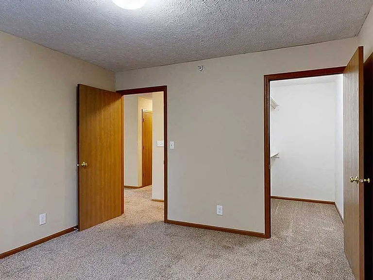 A comfortable bedroom in our 1 bedroom Imperial that features a large walk-in closet.