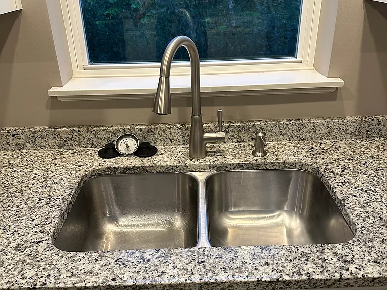 Kitchen sink area with window looking into the woods.