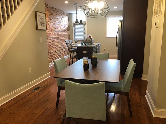 Furnished dining area with table and chairs leading into kitchen