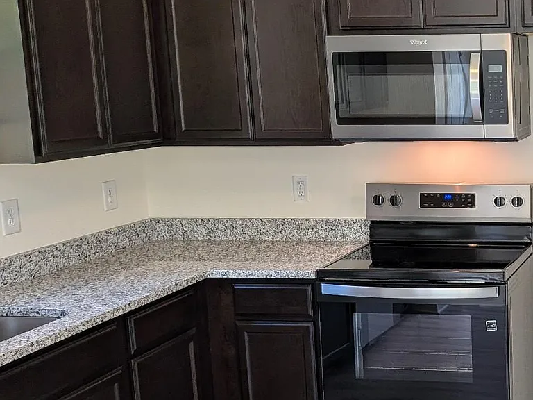 Enjoy cooking in a modern kitchen featuring a stainless-steel microwave and range oven, perfect for everyday meals and entertaining.
