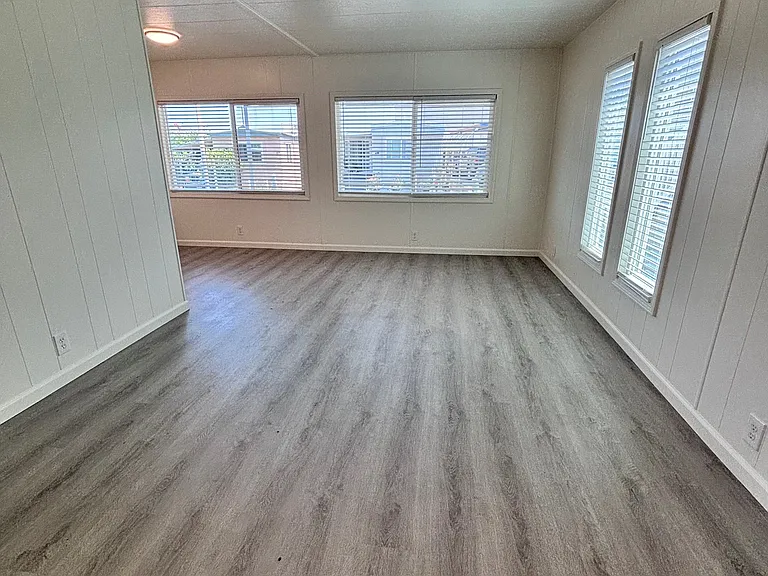 The living room welcomes you with an open, inviting layout designed for both comfort and functionality. Large windows allow natural light to fill the space, creating a bright and airy atmosphere.