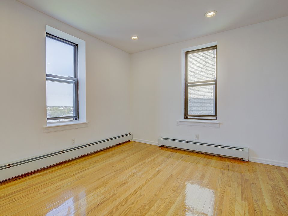 Unfurnished room featuring baseboard heating, wood finished floors, and recessed lighting