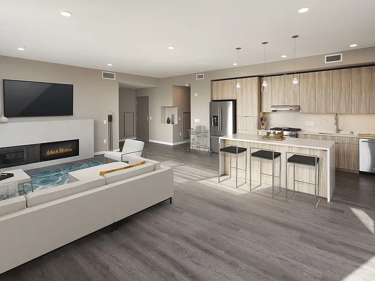 Signature Collection penthouse kitchen, dining area, and living room with fireplace and hard surface flooring.