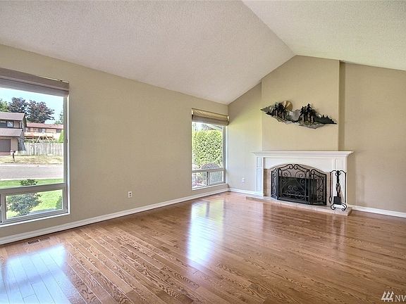 Spacious living room w/vaulted ceiling & cozy fireplace for year 'round enjoyment.
