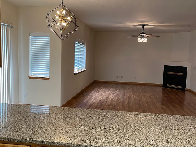Large family room with breakfast bar, gas fire place and laminated flooring.