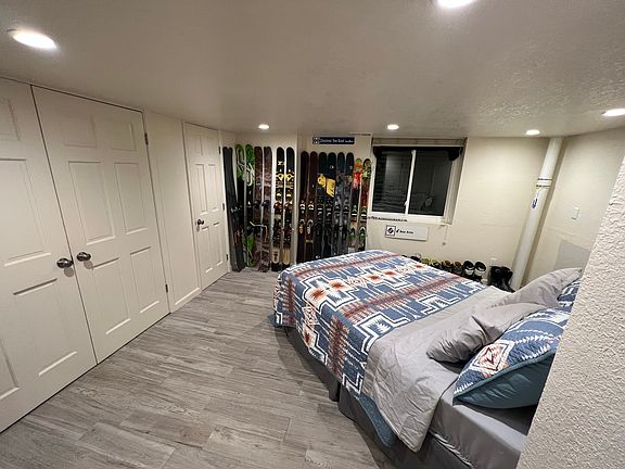 basement bedroom (adjacent to home theater) includes walk-in closet full of shelving, as well as laundry closet with storage