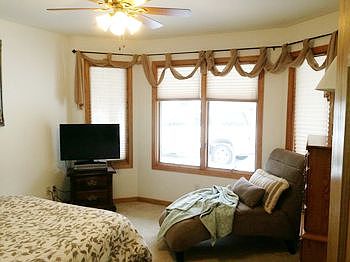 The guest bedroom in this home is lovely and with the angled wall with windows, provides added taste to the design and symmetry of this home.