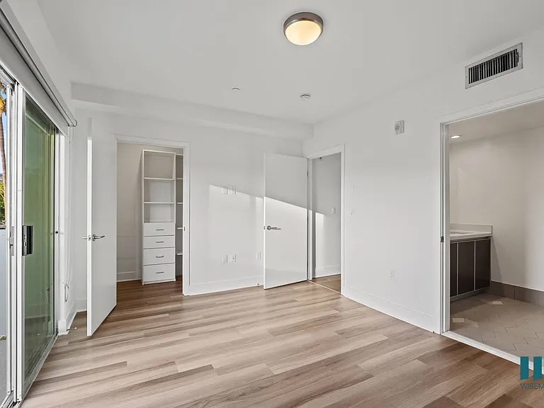 Bedroom with Walk-In Closet with Built-In Organizers, Bathroom, and Patio