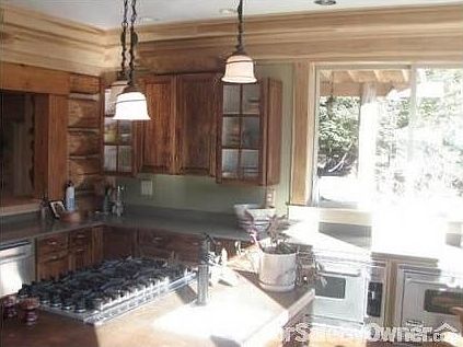 Kitchen surrounded on 3 sides by windows
						:
						It has ample counter space, 2 sinks, and a central island w/ 6 burner cook-top.