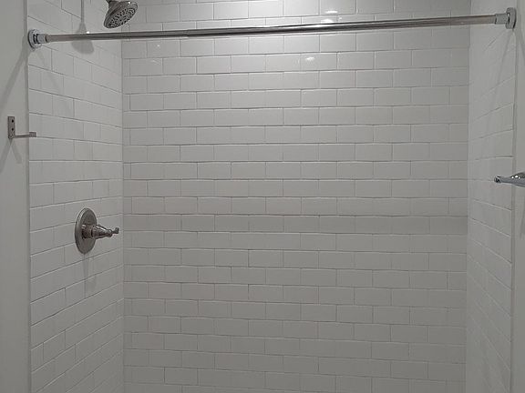 Walk-in shower with floor to ceiling subway tile ...