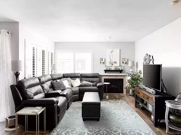 living room with fireplace and windows overlooking golf course